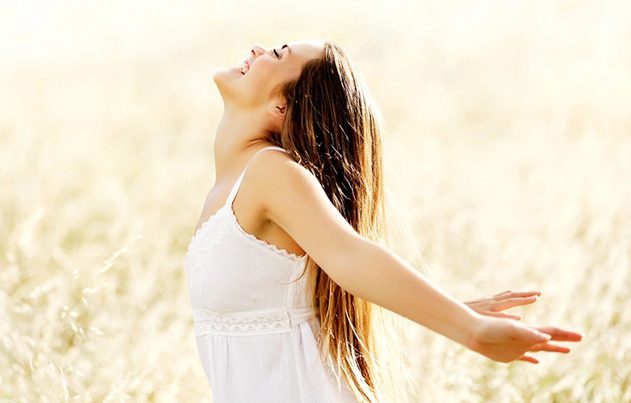 A woman in white dress with her arms outstretched.